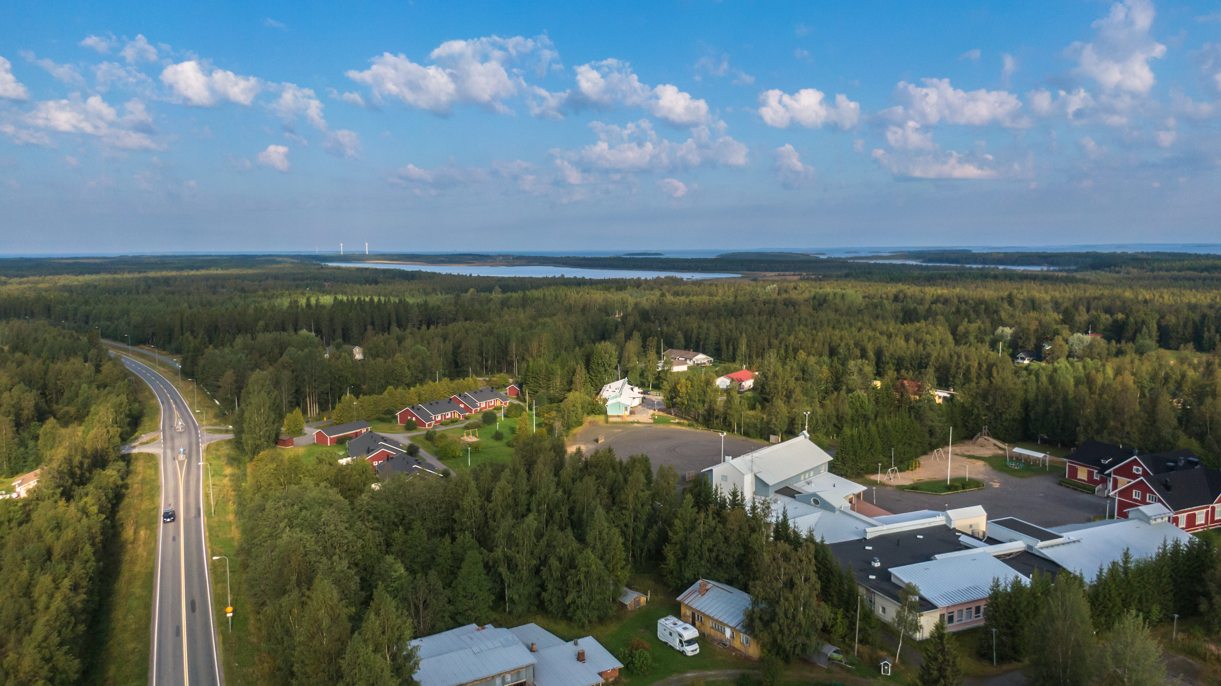 Dronen avulla otettu ilmakuva Oulunsalosta Salonpään kylämaisemasta. Sinisellä taivaalla valkoisia poutapilviä.