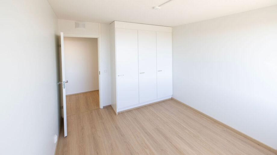 Makuuhuone, kaapistot ja avoin ovi käytävälle