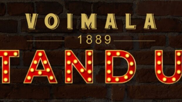 Kuvassa Voimala 1889 Stand Up teksti tiiliseinää kuvaavassa taustassa.