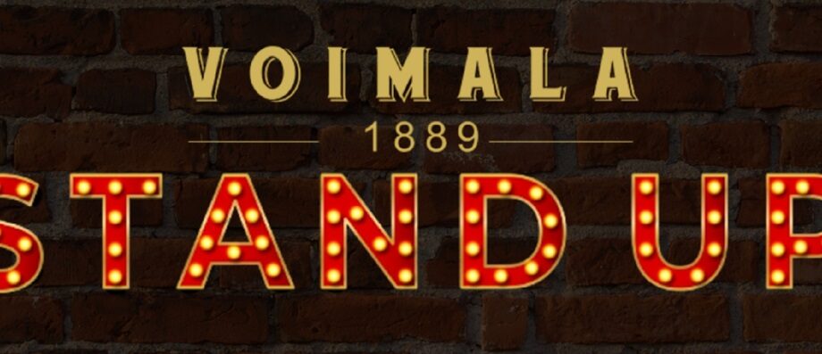 Kuvassa Voimala 1889 Stand Up teksti tiiliseinää kuvaavassa taustassa.