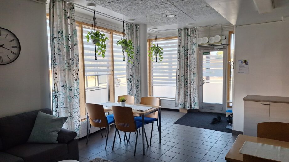 Ruokailutila ja olohuone suurilla ikkunoilla.