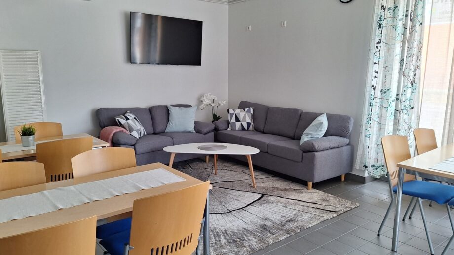 Olohuone, jossa sohva, sohvapöytä ja televisio.